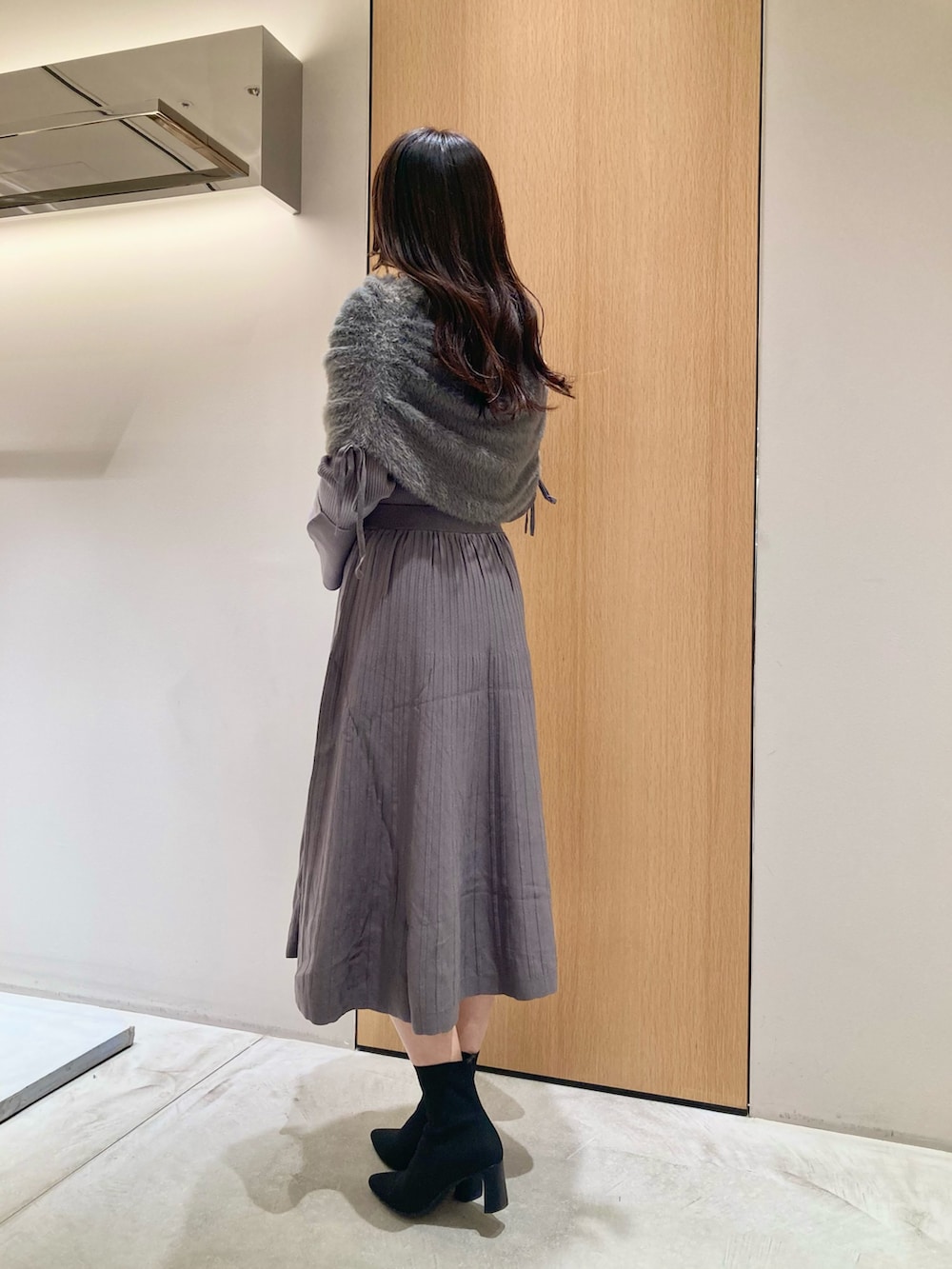 グレー系のワンピース、レッド系のハンドバッグを着用したレディースの秋コーディネートの4枚目の写真