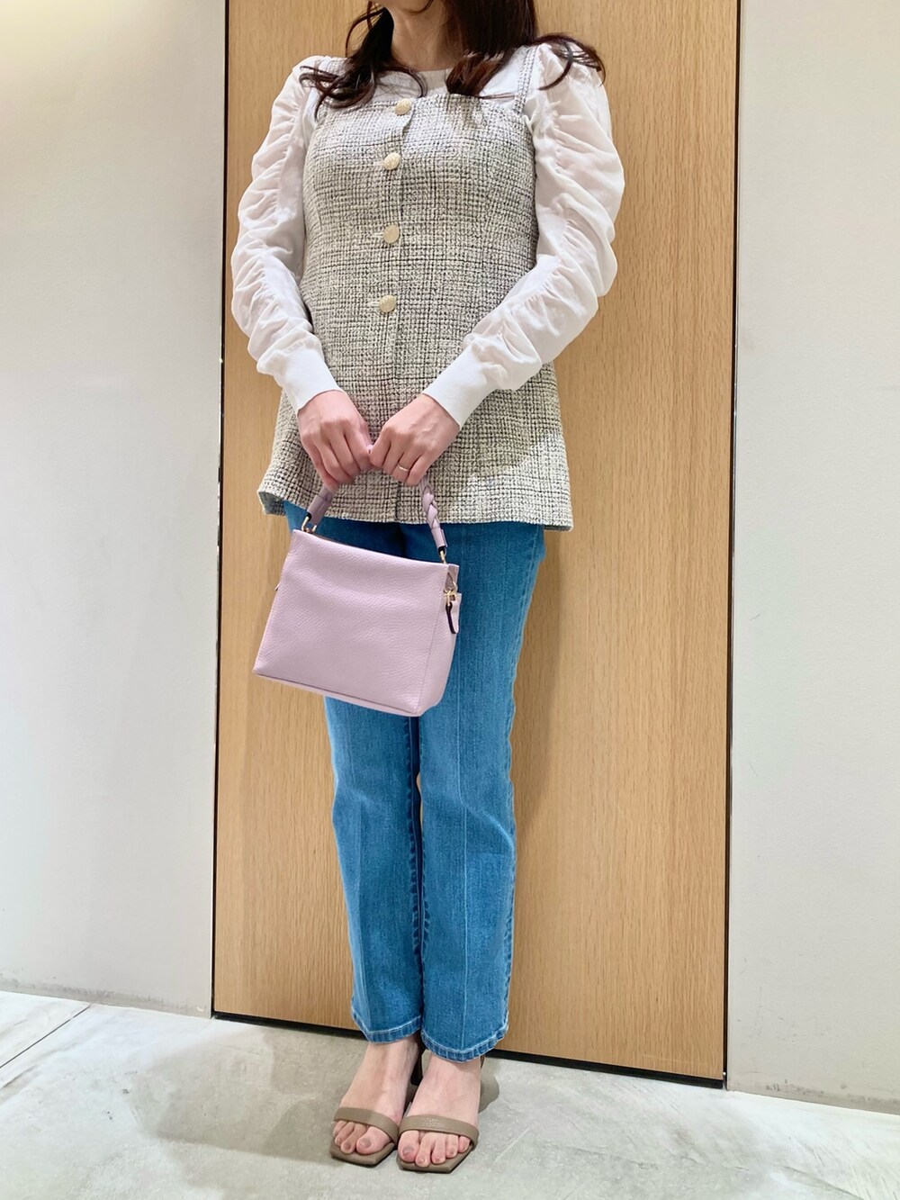 ホワイト系のニット/セーター、ホワイト系のベスト、ブルー系のデニムパンツを着用したレディースの春コーディネートの4枚目の写真