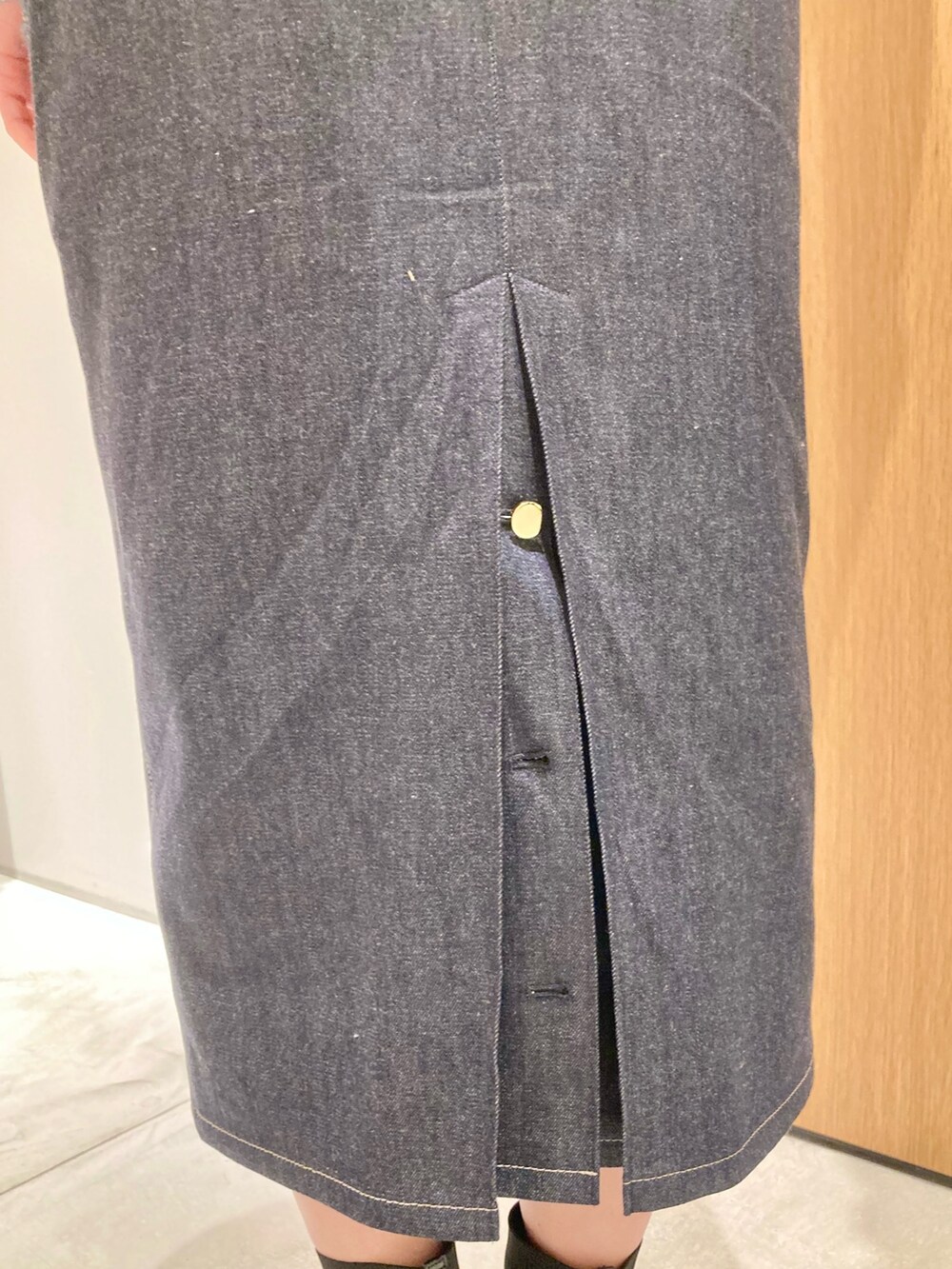 グリーン系のカーディガン/ボレロ、ホワイト系のハンドバッグ、ブルー系のデニムスカートを着用したレディースの冬コーディネートの7枚目の写真