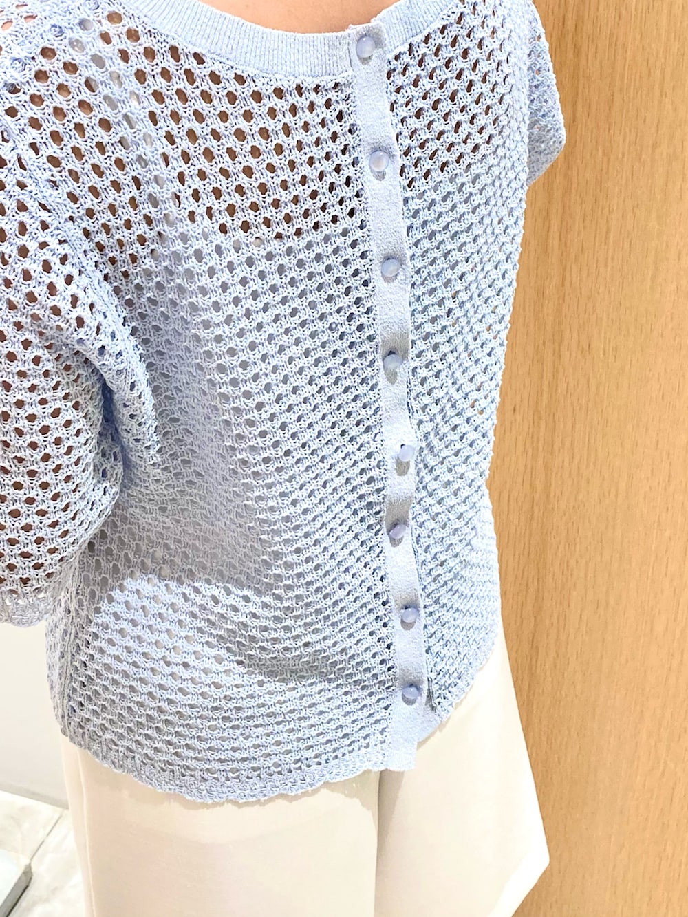 ブルー系のニット/セーター、ホワイト系のその他パンツ、ブルー系のハンドバッグを着用したレディースの夏コーディネートの3枚目の写真