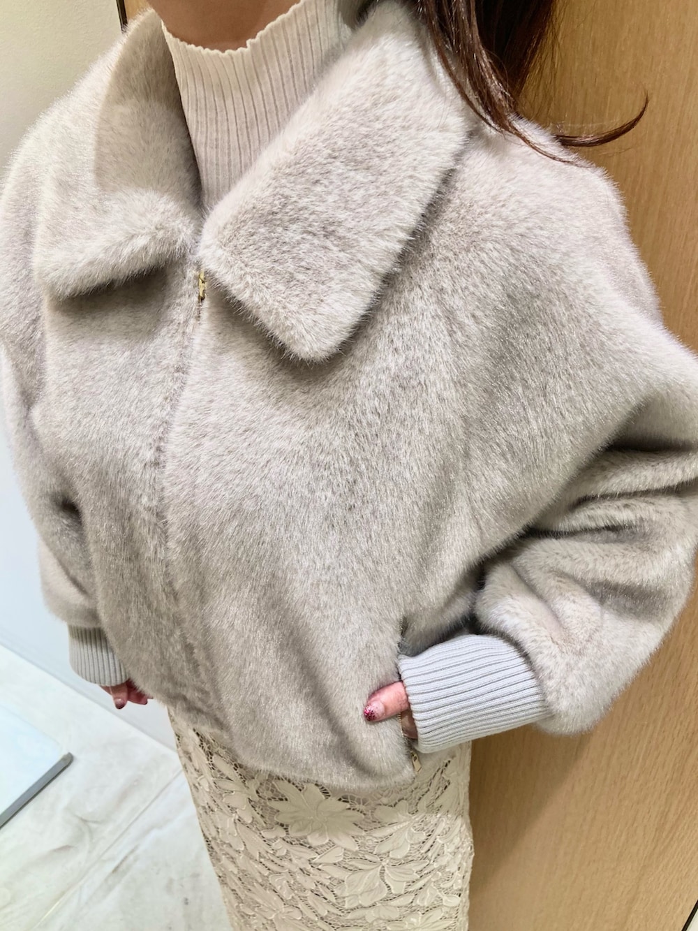 ベージュ系のブルゾン、ホワイト系のニット/セーター、ベージュ系のスカートを着用したレディースの秋コーディネートの4枚目の写真