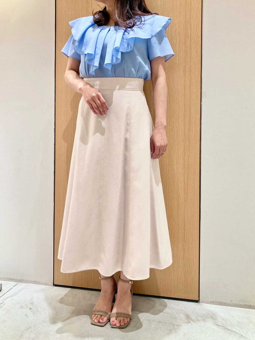 ブルー系のシャツ/ブラウス、ベージュ系のスカート、ホワイト系のイヤリングを着用したレディースの夏コーディネートの4枚目の写真