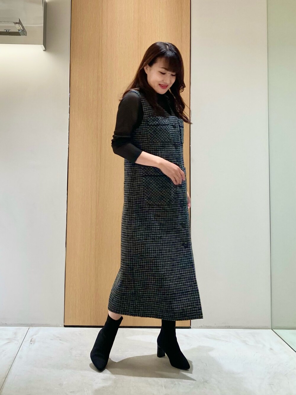 ブラック系のニット/セーター、ブラック系のワンピースを着用したレディースの秋コーディネートの2枚目の写真