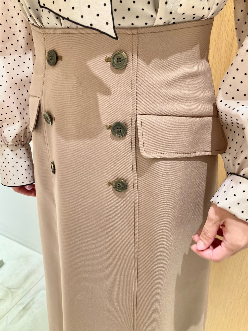 ベージュ系のシャツ/ブラウス、ベージュ系のスカート、ベージュ系のハンドバッグを着用したレディースの秋コーディネートの8枚目の写真