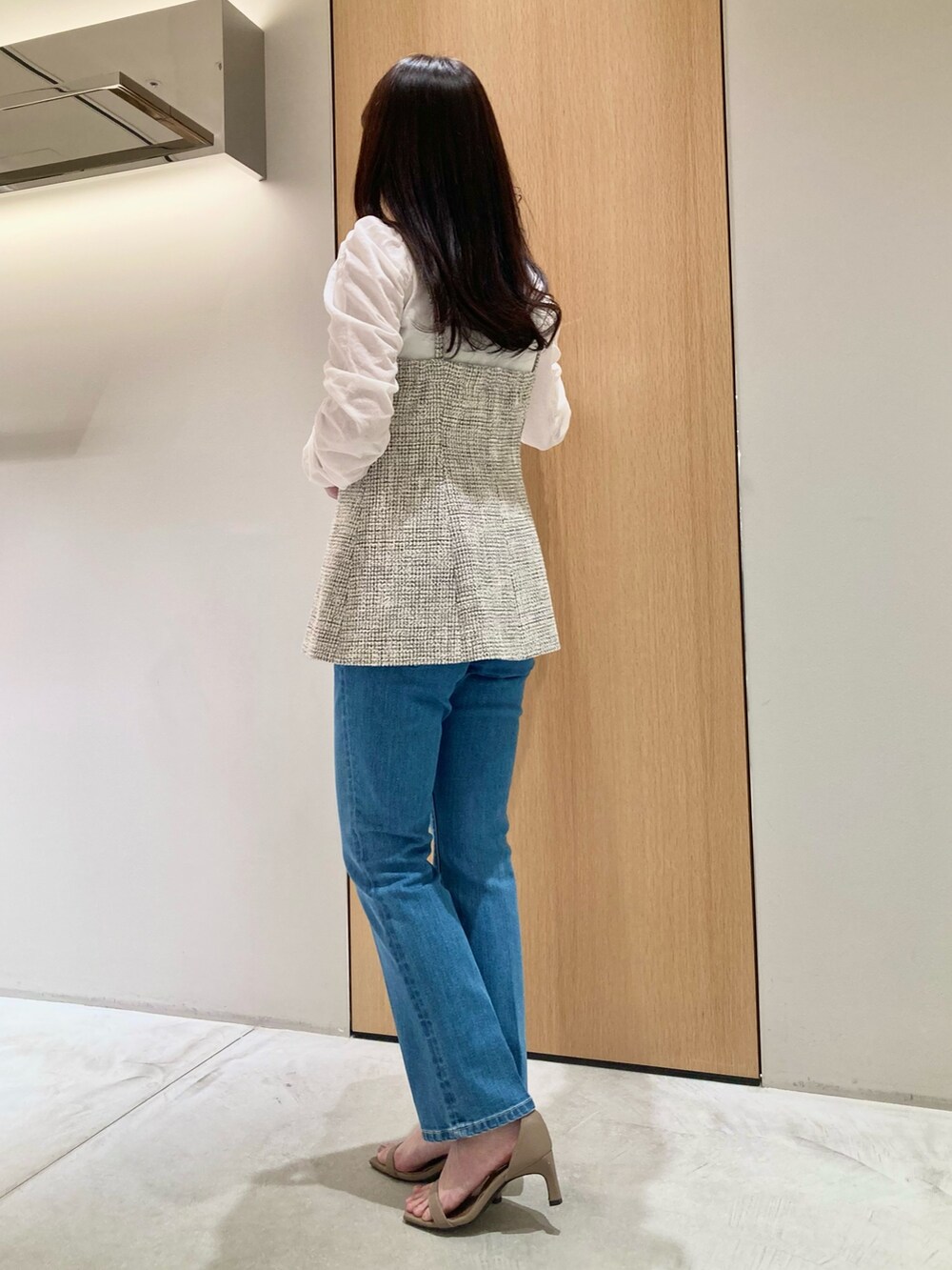 ホワイト系のニット/セーター、ホワイト系のベスト、ブルー系のデニムパンツを着用したレディースの春コーディネートの3枚目の写真