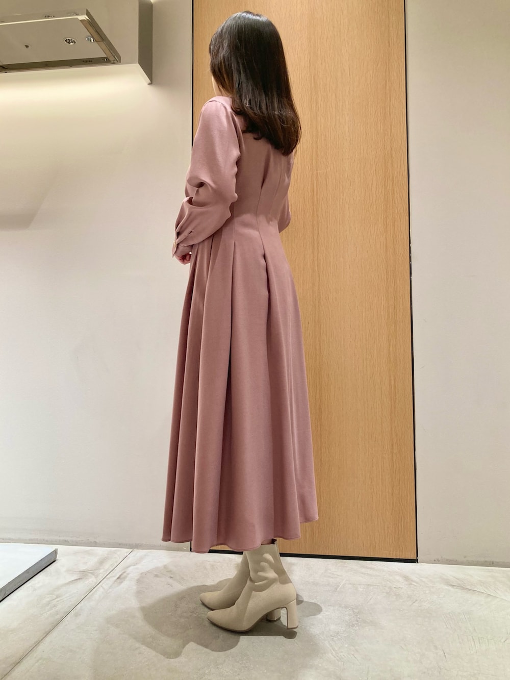 ピンク系のワンピース、ベージュ系のハンドバッグ、ゴールド系のリングを着用したレディースの秋コーディネートの3枚目の写真