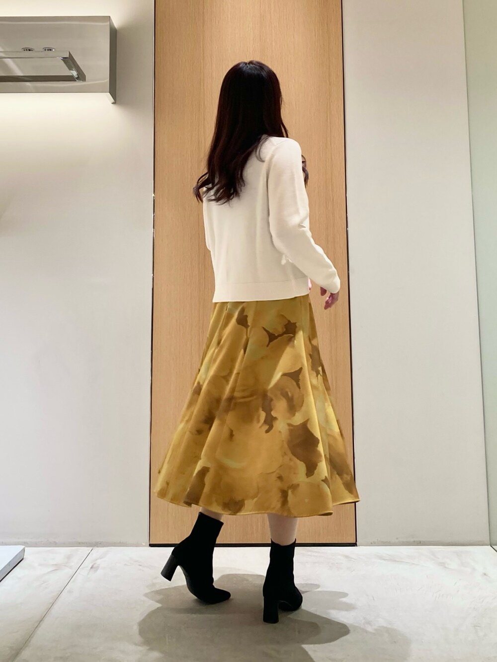 ホワイト系のカーディガン/ボレロ、イエロー系のスカートを着用したレディースの秋コーディネートの3枚目の写真
