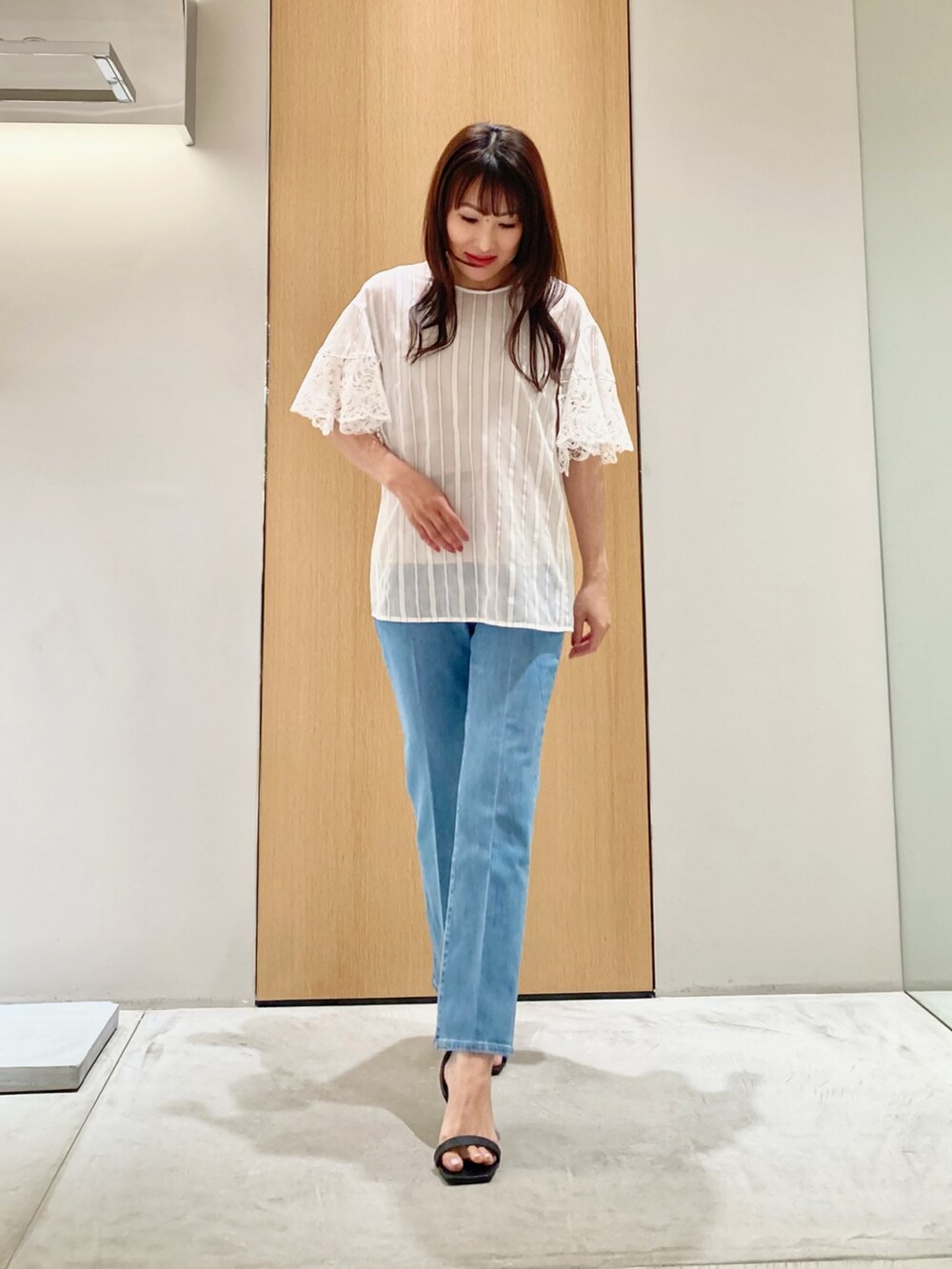 ホワイト系のシャツ/ブラウス、ブルー系のデニムパンツ、ゴールド系のイヤリングを着用したレディースの夏コーディネートの2枚目の写真