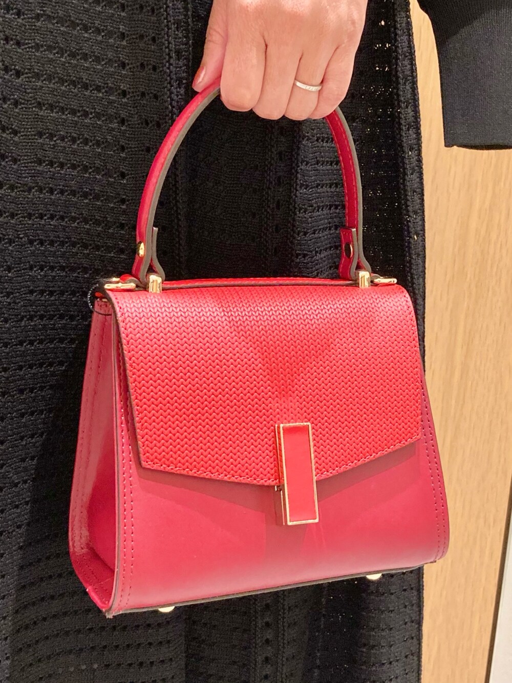 ブラック系のカーディガン/ボレロ、ブラック系のワンピース、レッド系のハンドバッグを着用したレディースの秋コーディネートの8枚目の写真