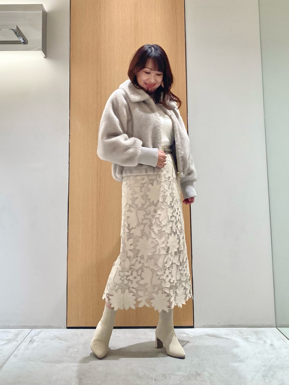 ベージュ系のブルゾン、ホワイト系のニット/セーター、ベージュ系のスカートを着用したレディースの秋コーディネートの2枚目の写真