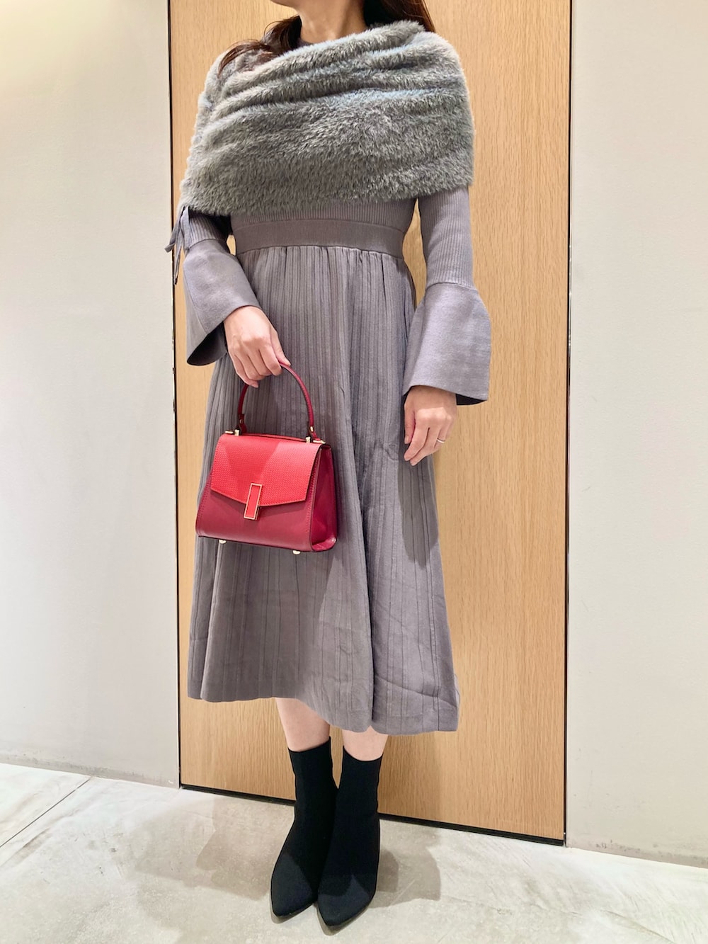 グレー系のワンピース、レッド系のハンドバッグを着用したレディースの秋コーディネートの3枚目の写真
