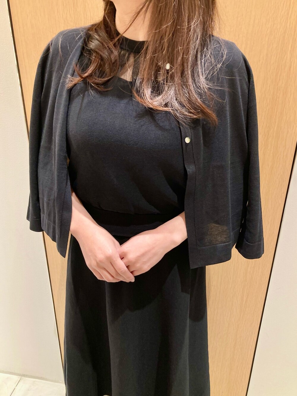 ブラック系のカーディガン/ボレロ、ブラック系のワンピース、ホワイト系のイヤリングを着用したレディースの春コーディネートの5枚目の写真