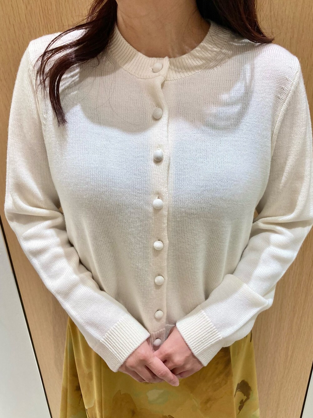 ホワイト系のカーディガン/ボレロ、イエロー系のスカートを着用したレディースの秋コーディネートの6枚目の写真