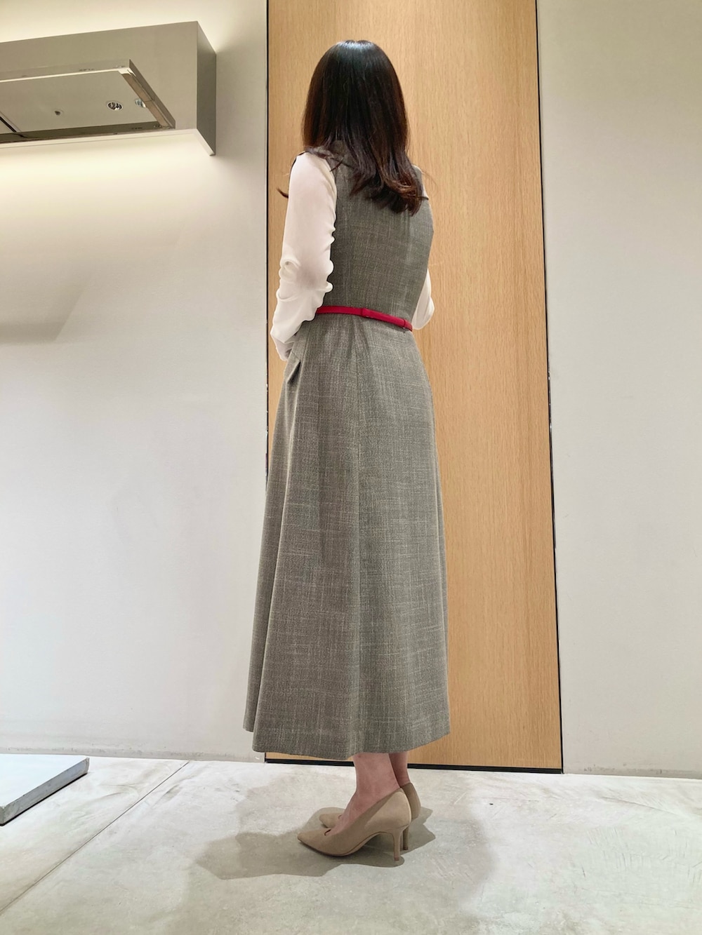 ベージュ系のワンピース、ホワイト系のTシャツ/カットソー、レッド系のベルトを着用したレディースの秋コーディネートの3枚目の写真