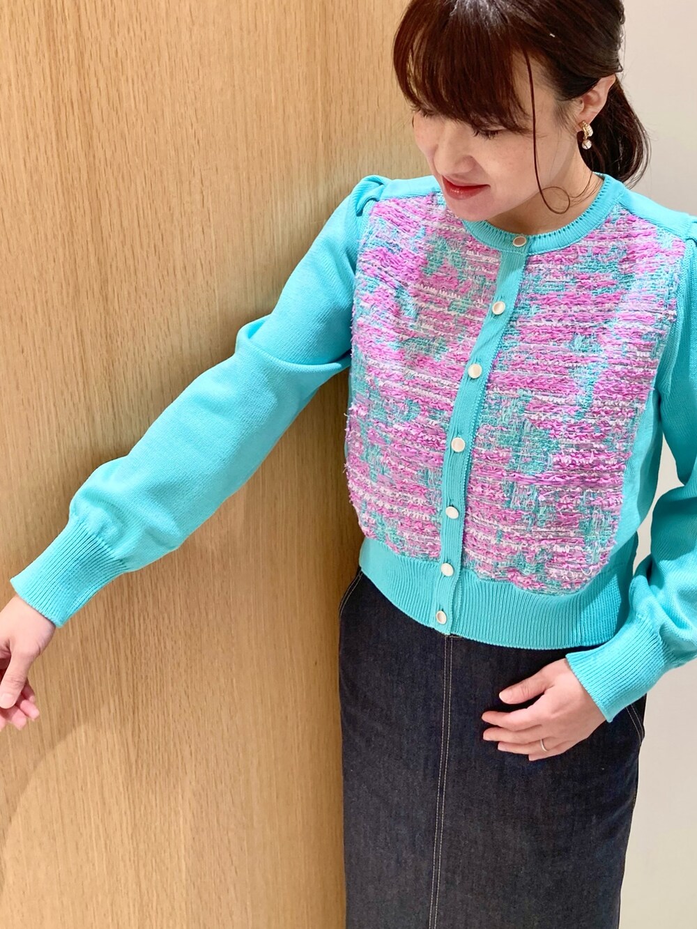 グリーン系のカーディガン/ボレロ、ホワイト系のハンドバッグ、ブルー系のデニムスカートを着用したレディースの冬コーディネートの4枚目の写真