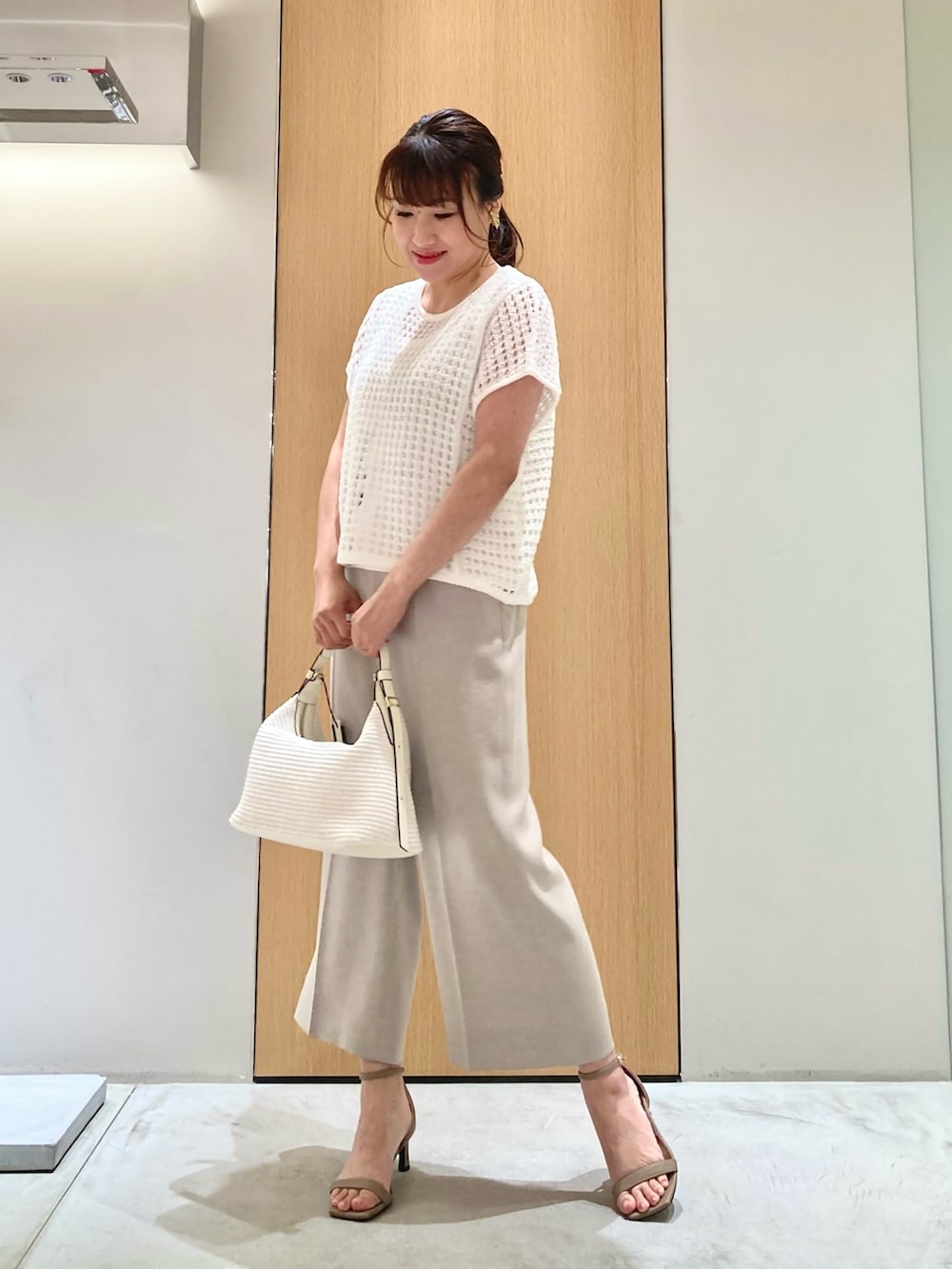 ホワイト系のニット/セーター、ホワイト系のタンクトップ、ベージュ系のその他パンツを着用したレディースの夏コーディネートの2枚目の写真