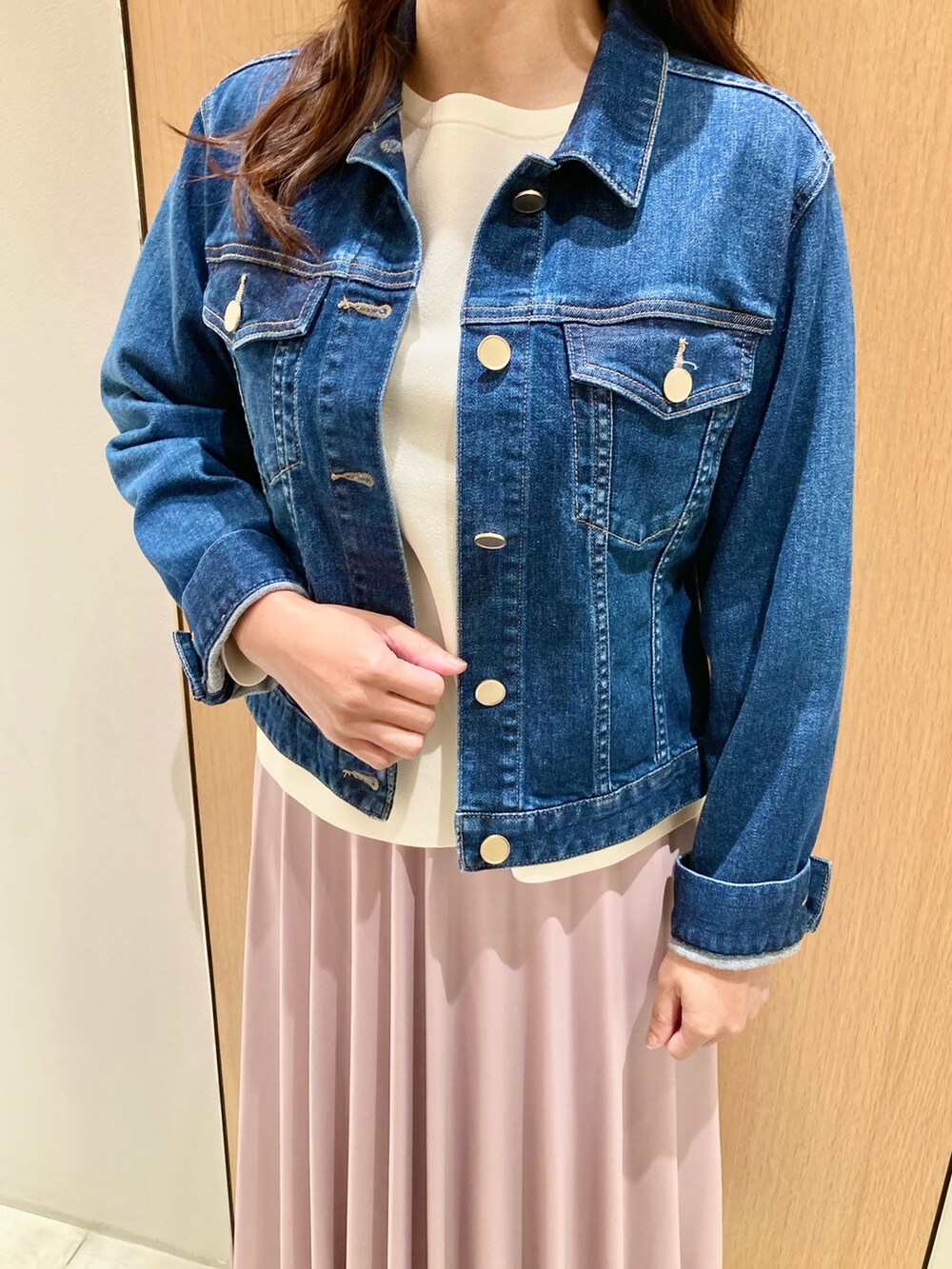 ブルー系のデニムジャケット、ホワイト系のニット/セーター、ピンク系のスカートを着用したレディースの秋コーディネートの6枚目の写真