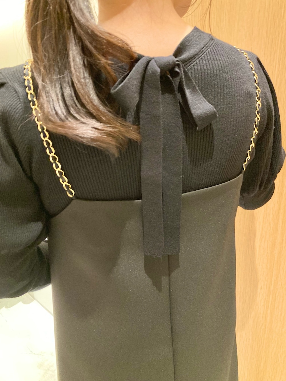 ブラック系のニット/セーター、ブラック系のワンピース、ホワイト系のバックパック/リュックを着用したレディースの秋コーディネートの5枚目の写真