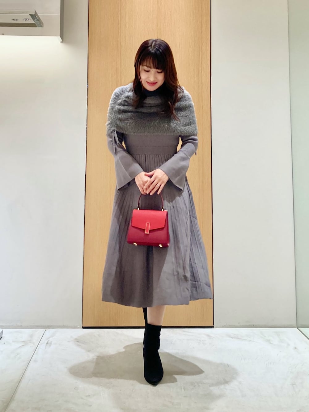 グレー系のワンピース、レッド系のハンドバッグを着用したレディースの秋コーディネートの2枚目の写真