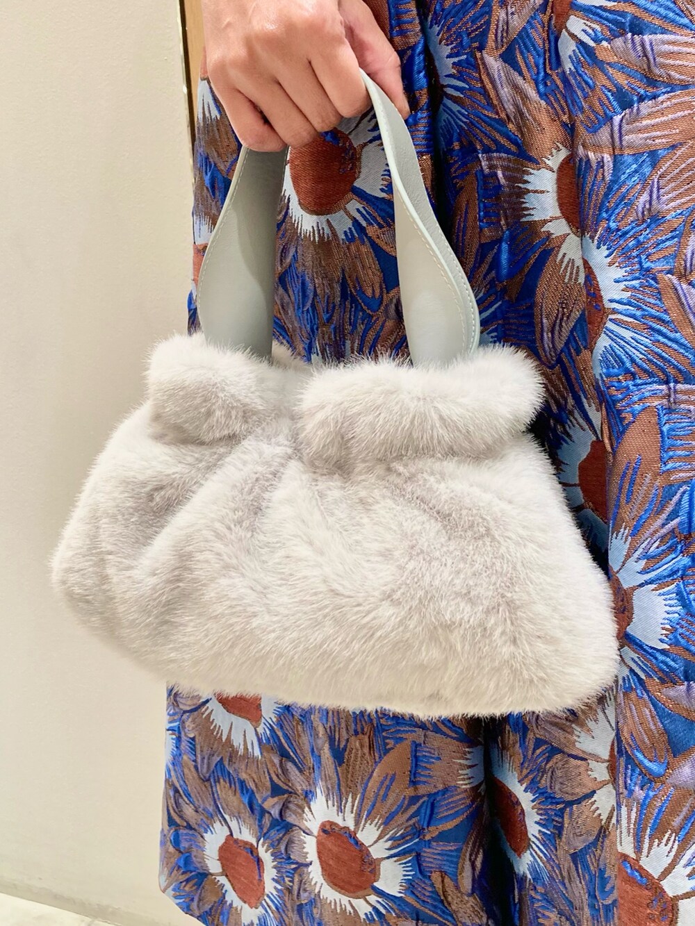 ブルー系のニット/セーター、ブルー系のハンドバッグ、ブルー系のスカートを着用したレディースの秋コーディネートの9枚目の写真