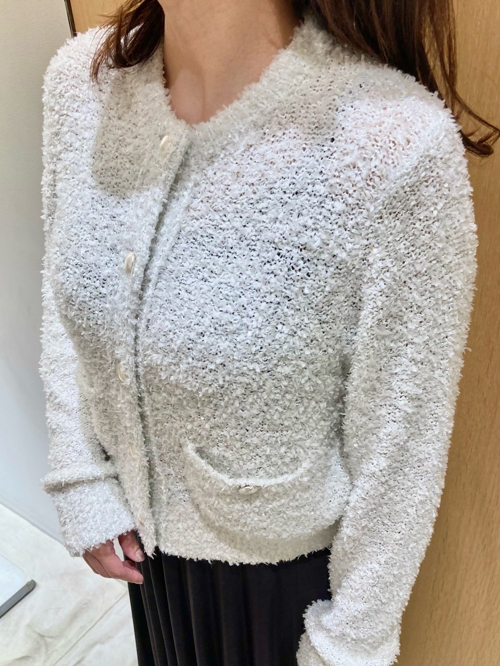 ホワイト系のカーディガン/ボレロ、ベージュ系のハンドバッグ、グレー系のスカートを着用したレディースの秋コーディネートの5枚目の写真