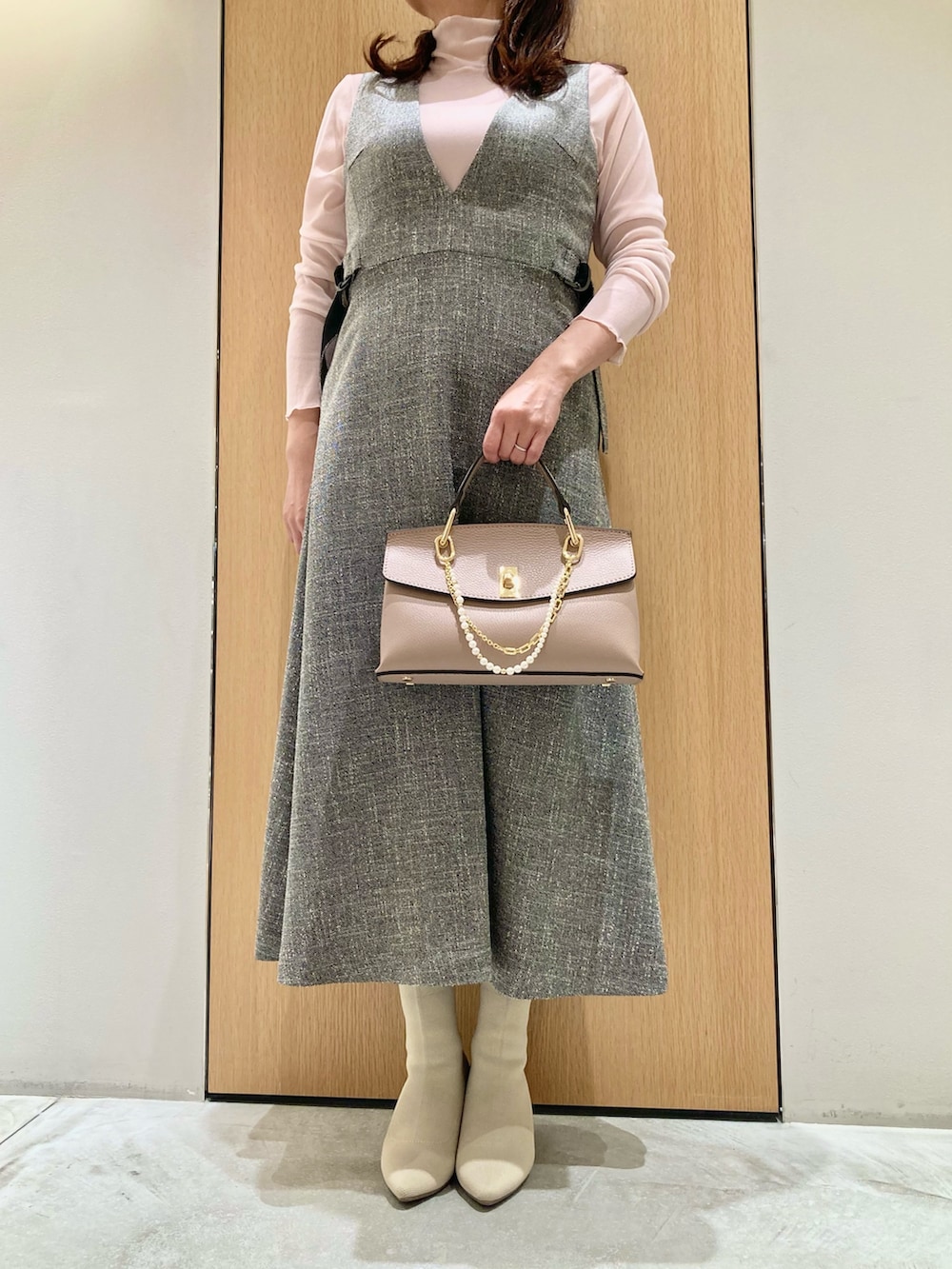 グレー系のワンピース、ピンク系のTシャツ/カットソー、ピンク系のハンドバッグを着用したレディースの秋コーディネートの3枚目の写真