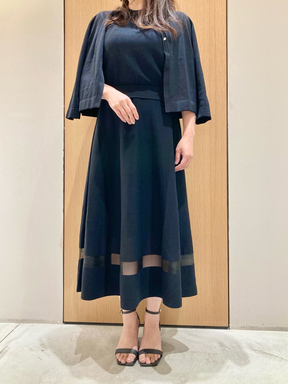 ブラック系のカーディガン/ボレロ、ブラック系のワンピース、ホワイト系のイヤリングを着用したレディースの春コーディネートの4枚目の写真