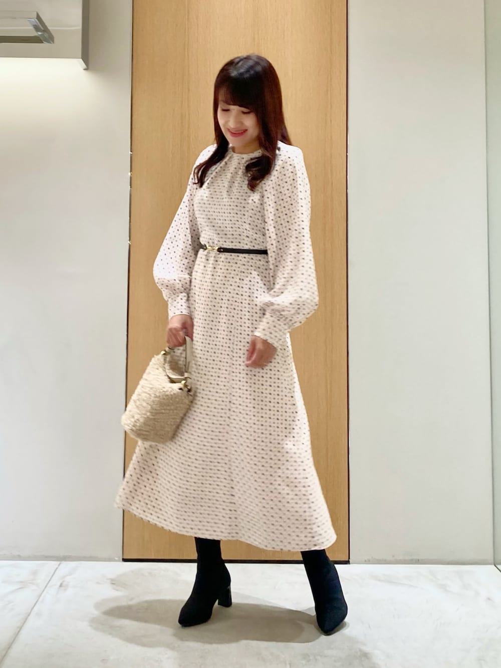 ベージュ系のワンピース、ホワイト系のハンドバッグを着用したレディースの秋コーディネートの2枚目の写真