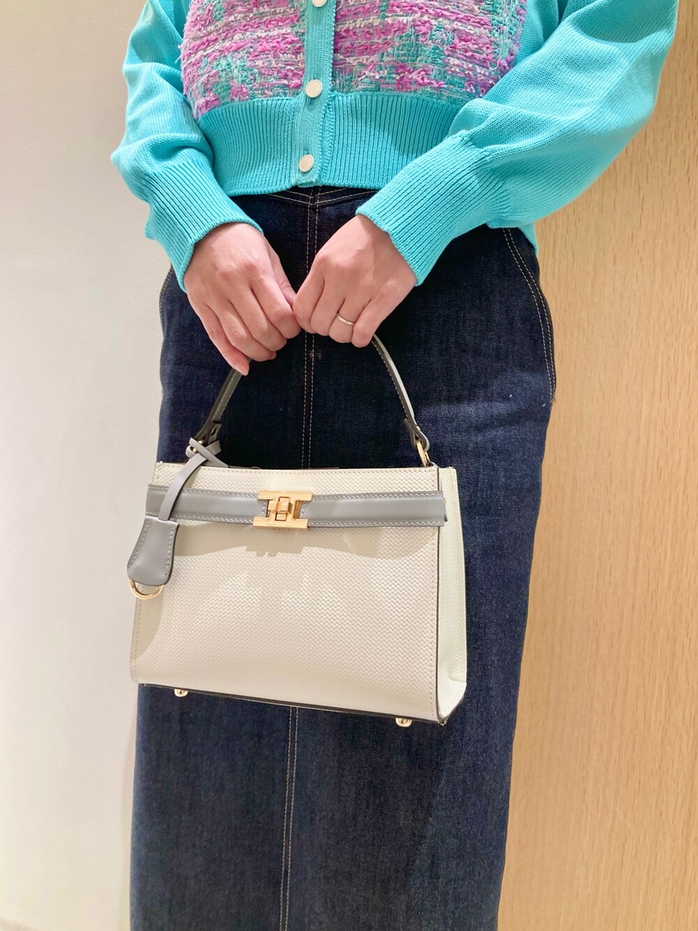 グリーン系のカーディガン/ボレロ、ホワイト系のハンドバッグ、ブルー系のデニムスカートを着用したレディースの冬コーディネートの10枚目の写真