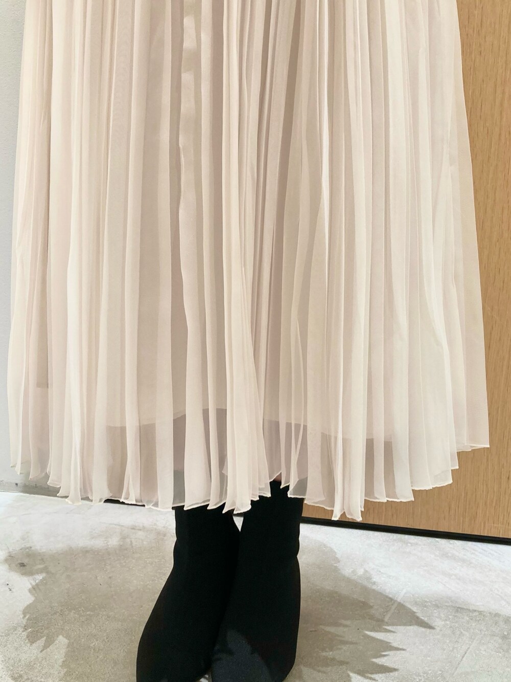 グレー系のニット/セーター、ホワイト系のスカート、シルバー系のネックレスを着用したレディースの秋コーディネートの9枚目の写真