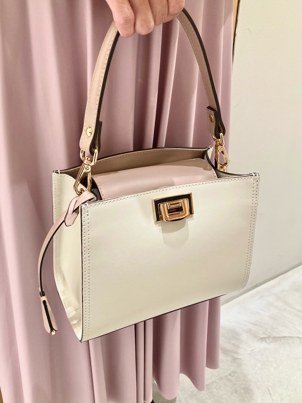 ブルー系のデニムジャケット、ホワイト系のニット/セーター、ピンク系のスカートを着用したレディースの秋コーディネートの9枚目の写真