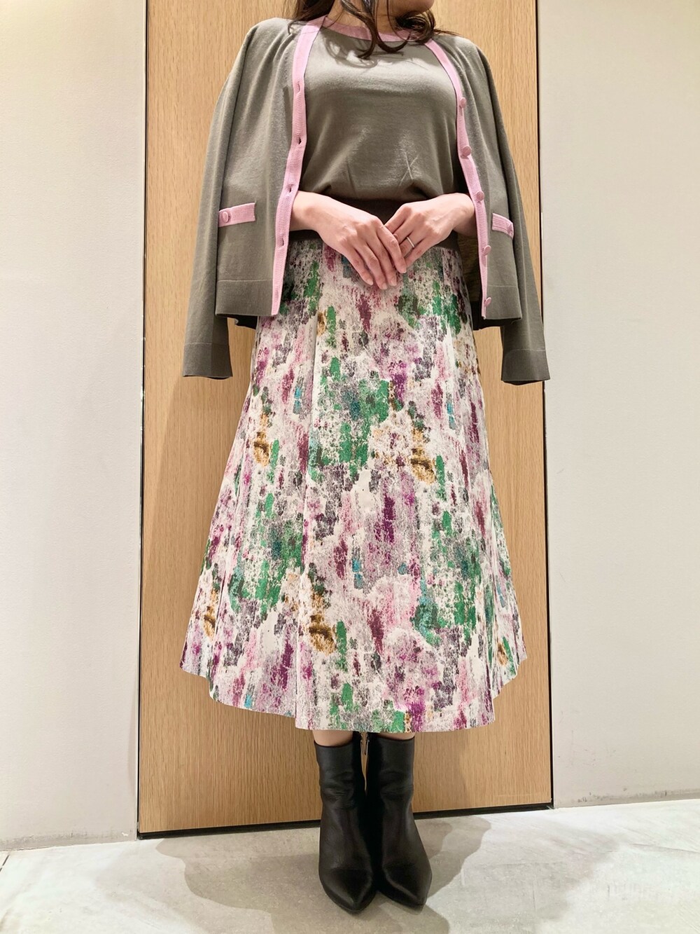 ベージュ系のカーディガン/ボレロ、ベージュ系のニット/セーター、パープル系のスカートを着用したレディースの秋コーディネートの5枚目の写真