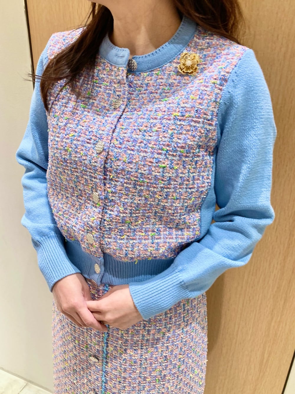 ブルー系のカーディガン/ボレロ、ブルー系のスカート、ゴールド系のイヤリングを着用したレディースの春コーディネートの4枚目の写真