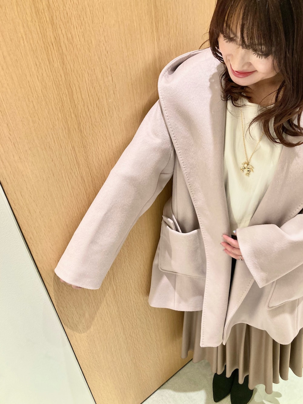 ベージュ系のその他アウター、ホワイト系のニット/セーター、ブラウン系のスカートを着用したレディースの秋コーディネートの3枚目の写真