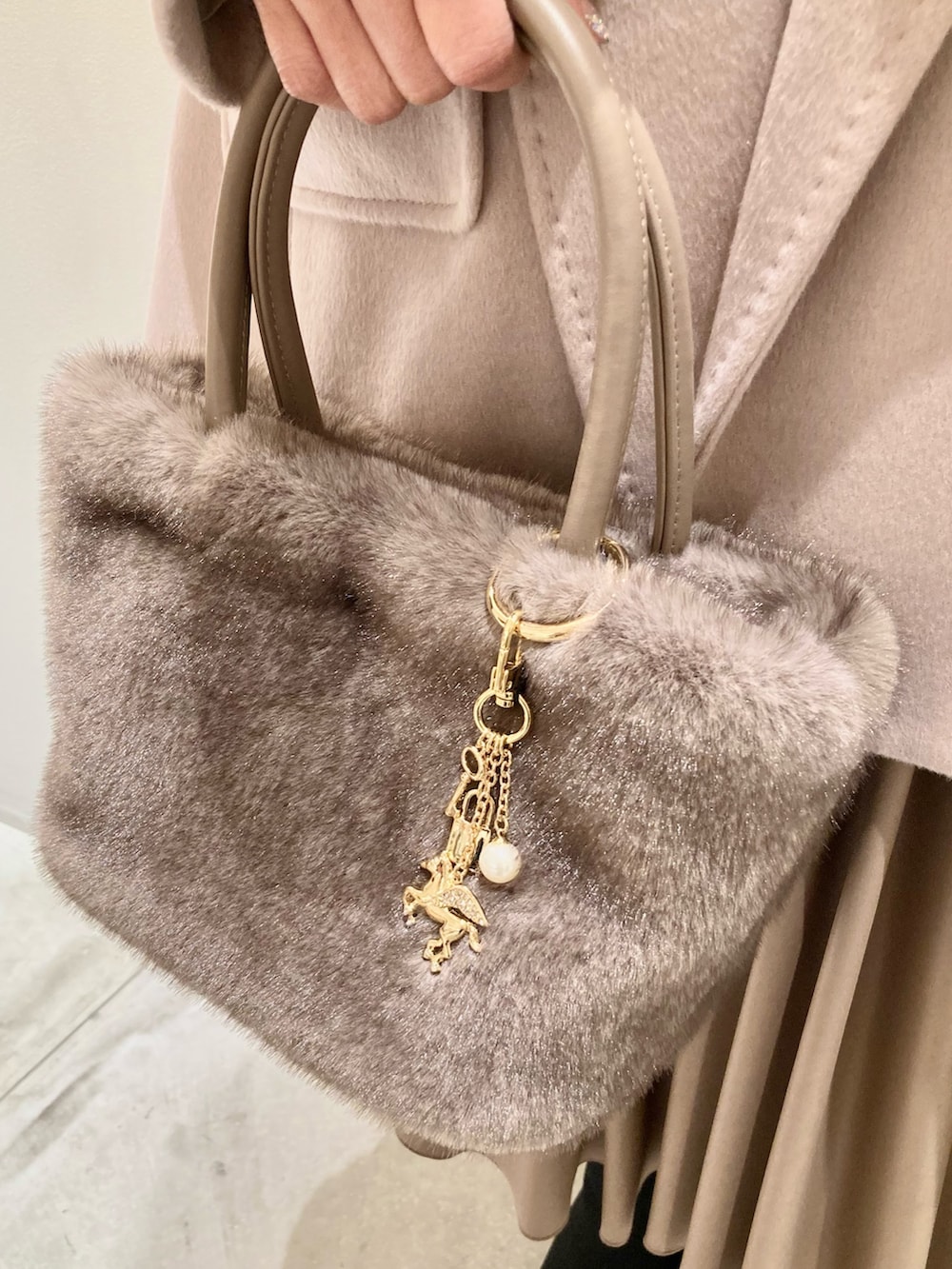 ベージュ系のその他アウター、ホワイト系のニット/セーター、ブラウン系のスカートを着用したレディースの秋コーディネートの7枚目の写真