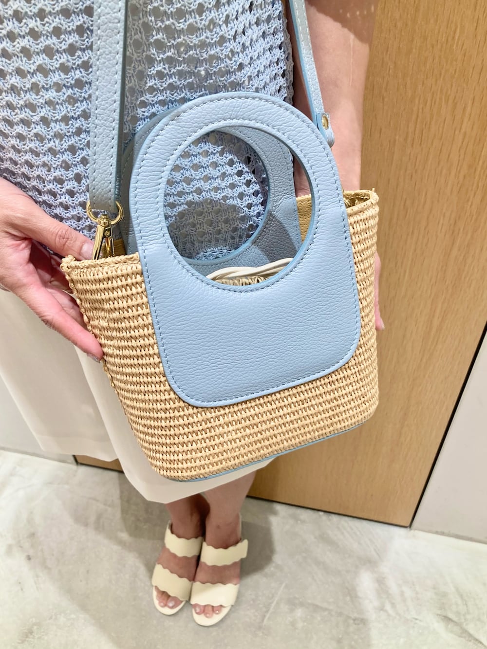 ブルー系のニット/セーター、ホワイト系のその他パンツ、ブルー系のハンドバッグを着用したレディースの夏コーディネートの9枚目の写真