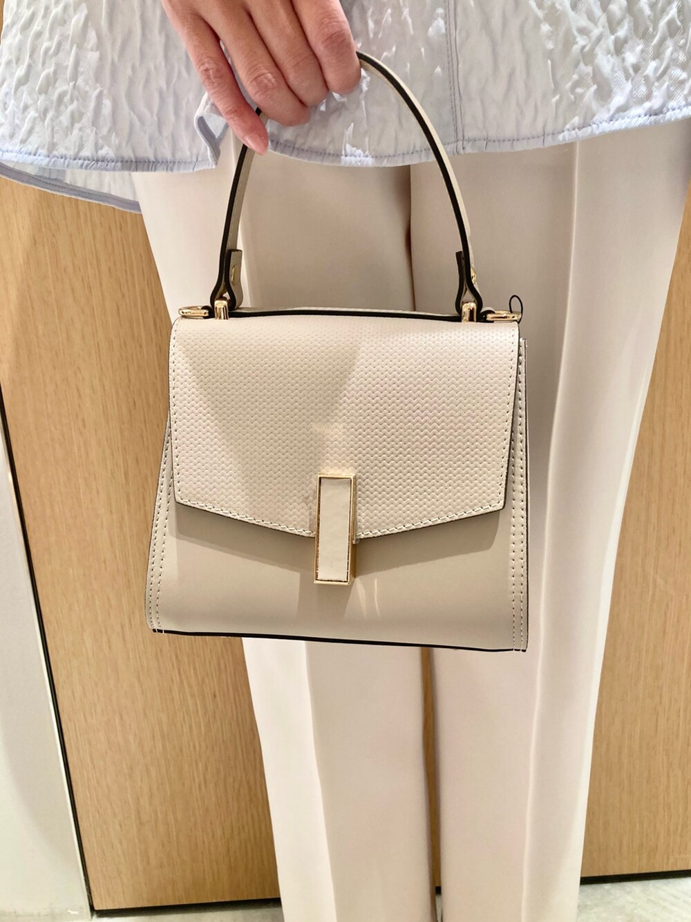 ベージュ系のトートバッグ、ブルー系のシャツ/ブラウス、ホワイト系のその他パンツを着用したレディースの冬コーディネートの5枚目の写真