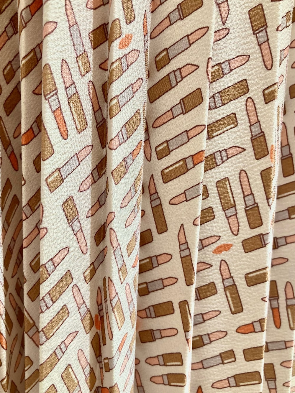 ピンク系のカーディガン/ボレロ、ベージュ系のスカート、ベージュ系のハンドバッグを着用したレディースの秋コーディネートの7枚目の写真