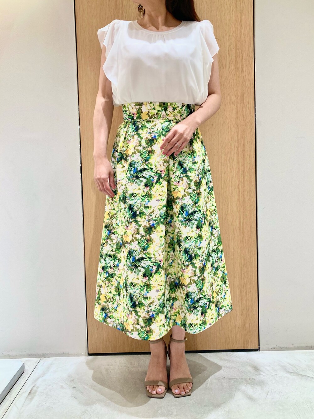 ホワイト系のその他トップス、グリーン系のスカート、ゴールド系のイヤリングを着用したレディースの夏コーディネートの4枚目の写真