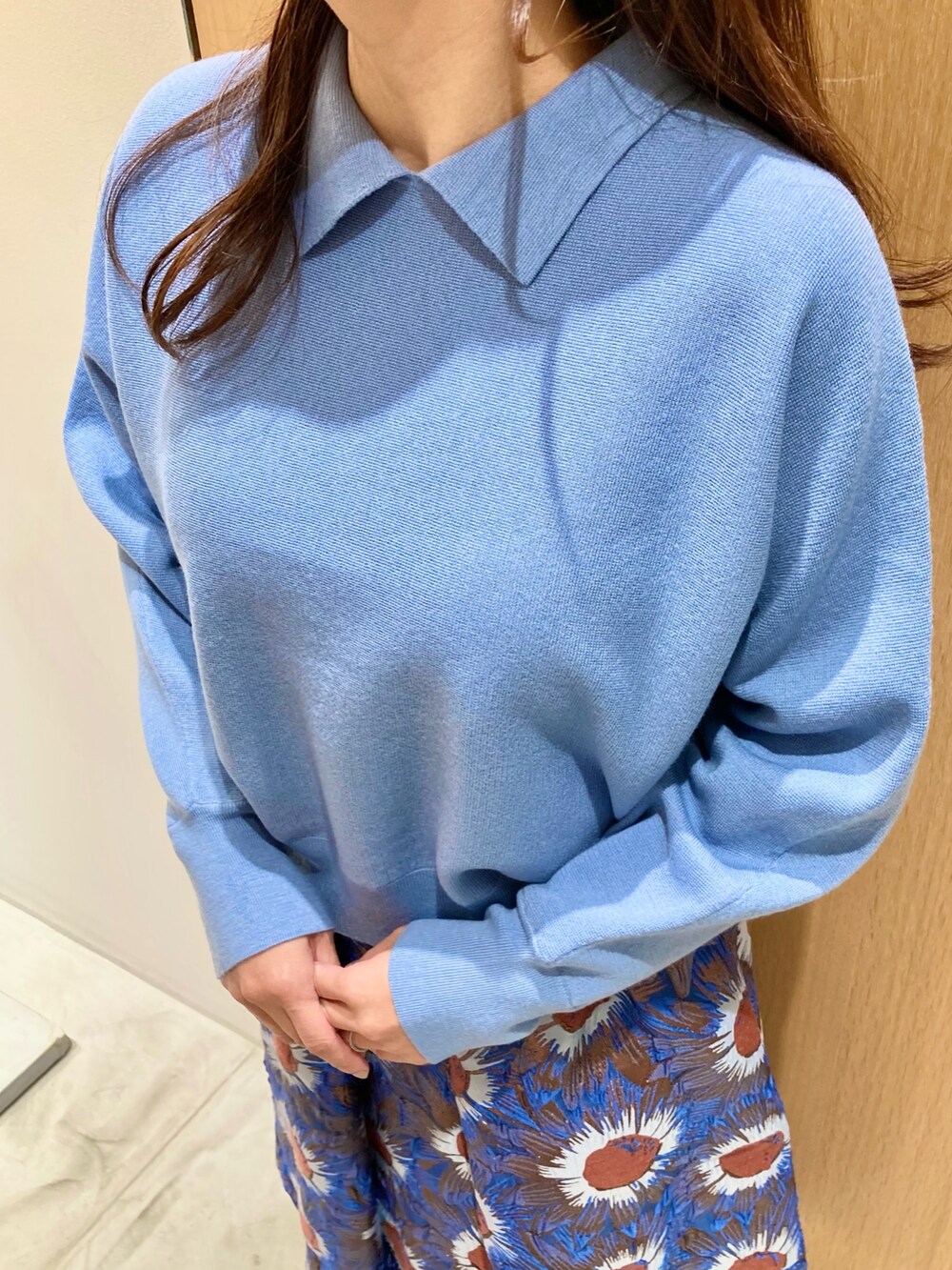 ブルー系のニット/セーター、ブルー系のハンドバッグ、ブルー系のスカートを着用したレディースの秋コーディネートの5枚目の写真