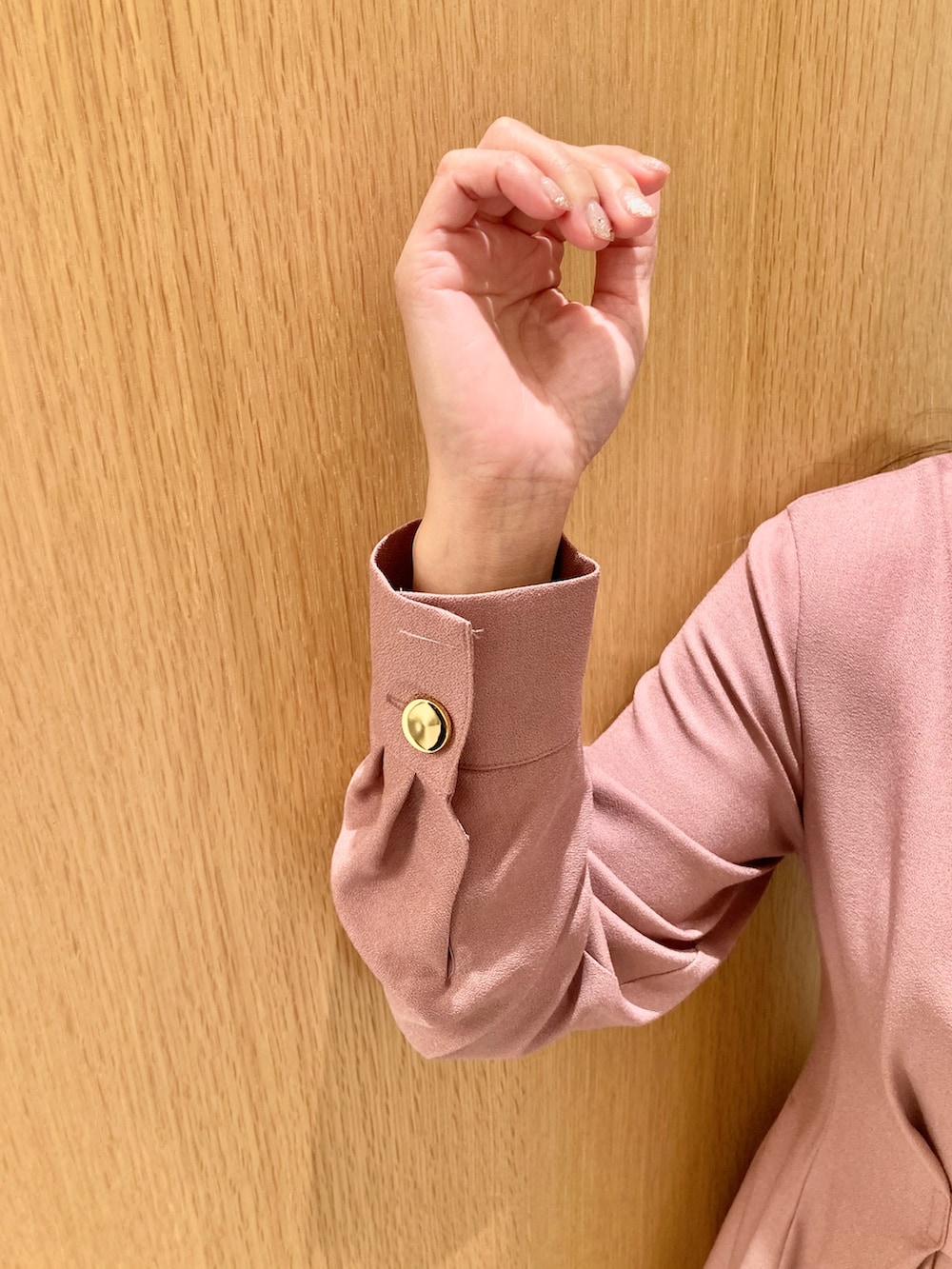 ピンク系のワンピース、ベージュ系のハンドバッグ、ゴールド系のリングを着用したレディースの秋コーディネートの6枚目の写真