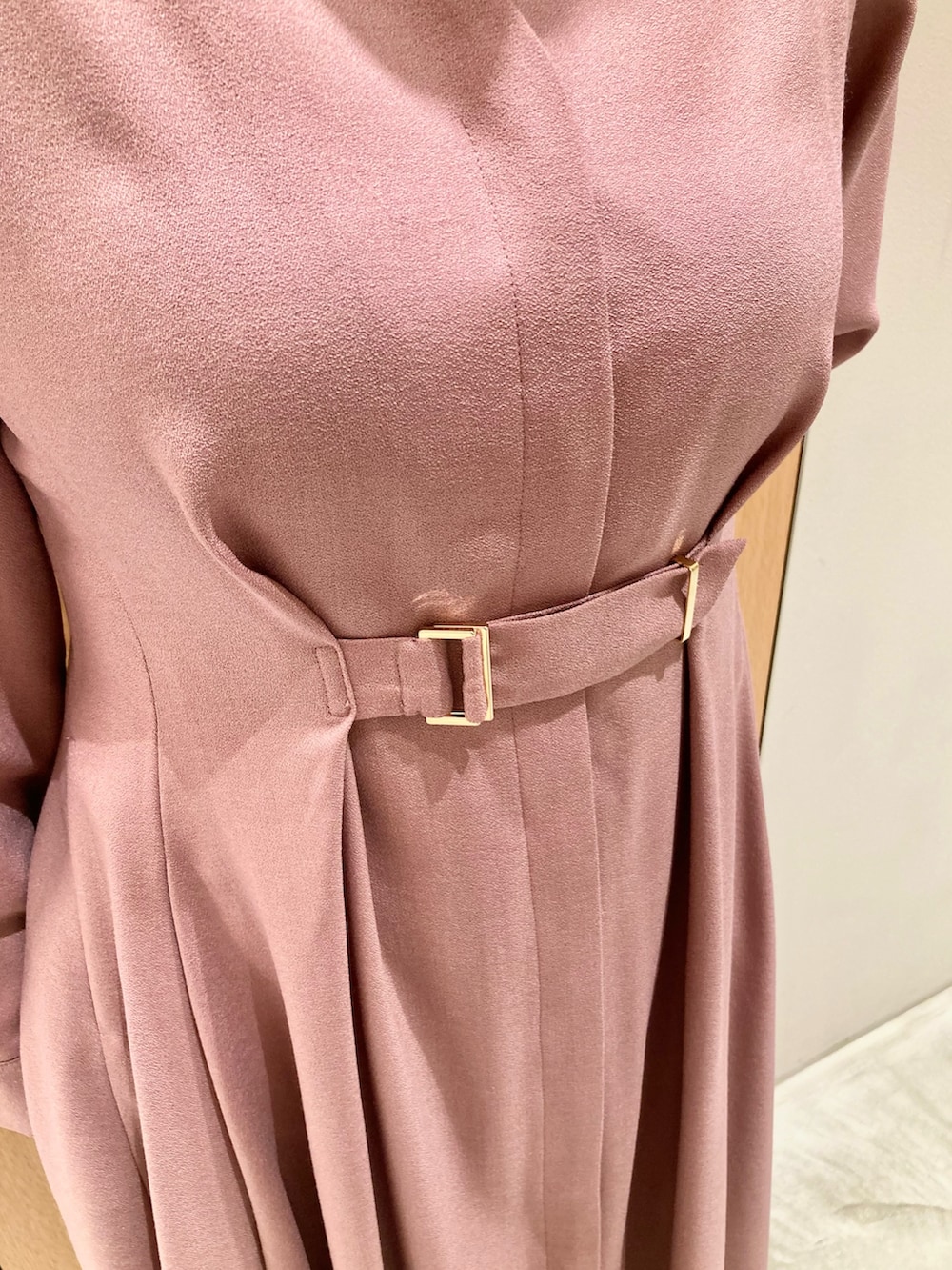 ピンク系のワンピース、ベージュ系のハンドバッグ、ゴールド系のリングを着用したレディースの秋コーディネートの5枚目の写真