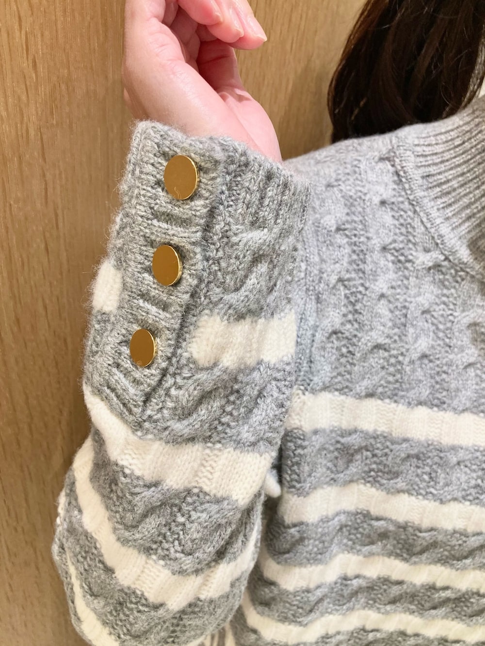 グレー系のニット/セーター、ブルー系のその他パンツ、ホワイト系のハンドバッグを着用したレディースの冬コーディネートの4枚目の写真