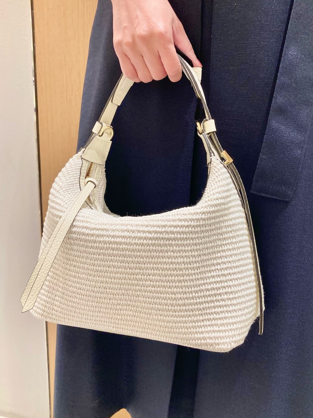 ブルー系のワンピース、ホワイト系のハンドバッグ、ホワイト系のイヤリングを着用したレディースの夏コーディネートの9枚目の写真