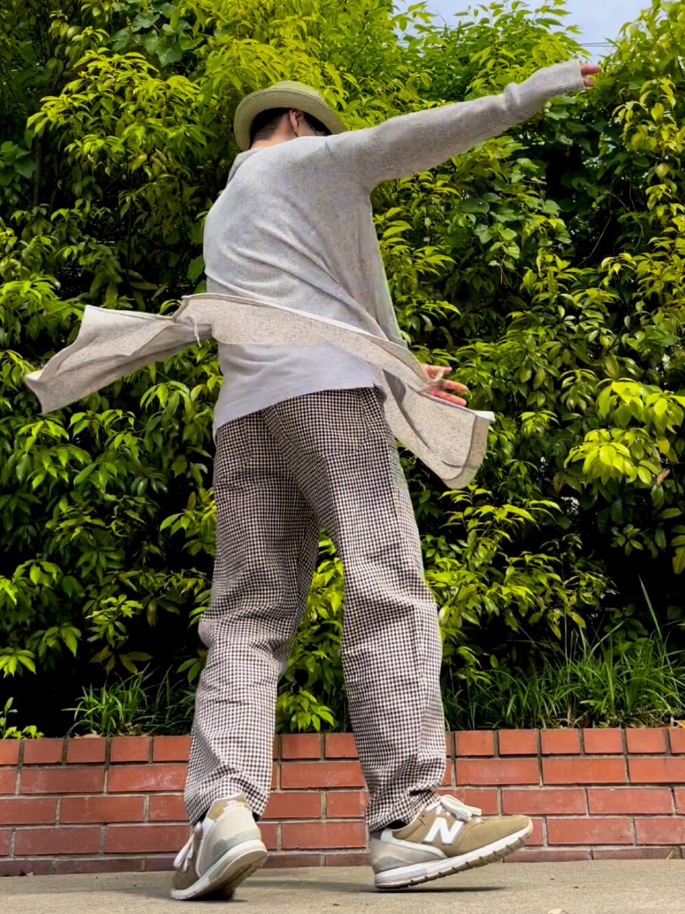 グリーン系のスニーカー、ブラウン系のパンツ、ベージュ系のカーディガン/ボレロを着用したメンズの春コーディネートの3枚目の写真