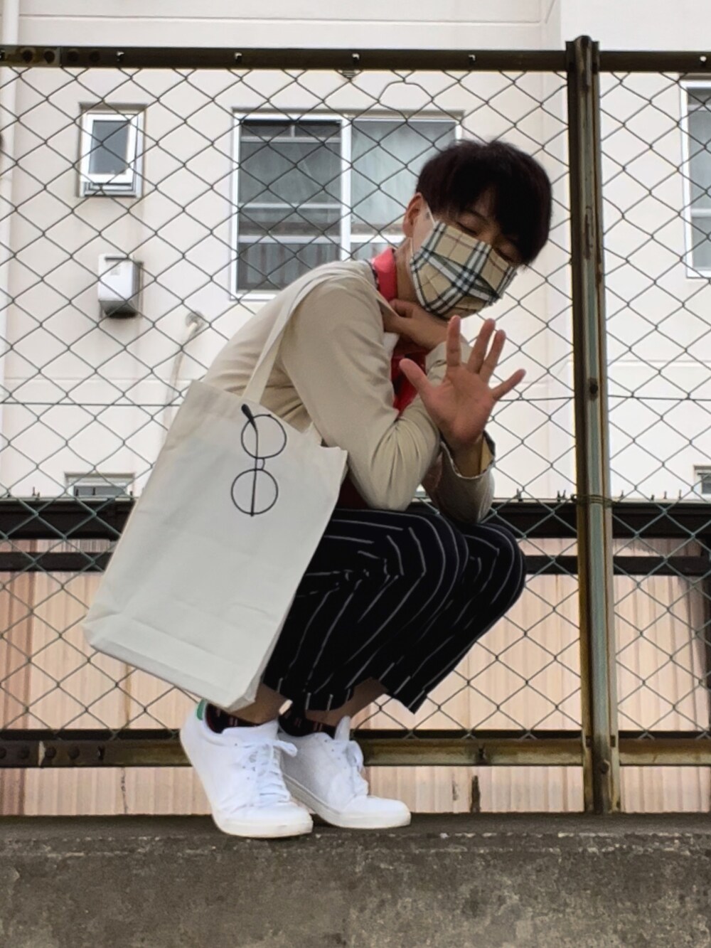 ホワイト系のスニーカー、ブルー系のパンツ、ピンク系のポロシャツを着用したメンズの夏コーディネートの5枚目の写真