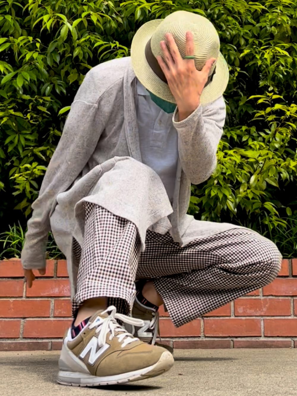 グリーン系のスニーカー、ブラウン系のパンツ、ベージュ系のカーディガン/ボレロを着用したメンズの春コーディネートの2枚目の写真