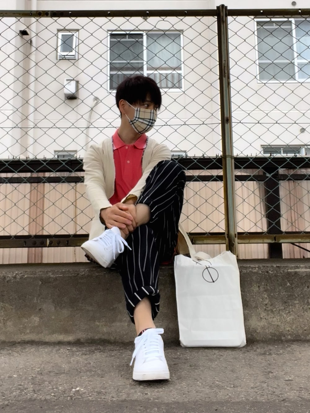 ホワイト系のスニーカー、ブルー系のパンツ、ピンク系のポロシャツを着用したメンズの夏コーディネートの2枚目の写真