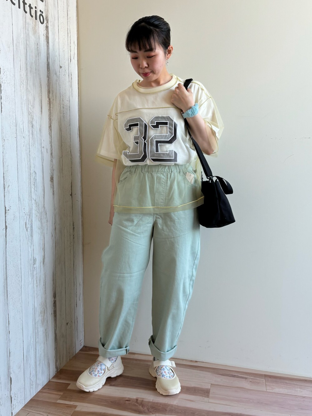 グリーン系のTシャツ/カットソー、グリーン系のパンツ、ブラック系のハンドバッグを着用したレディースの春コーディネートの4枚目の写真