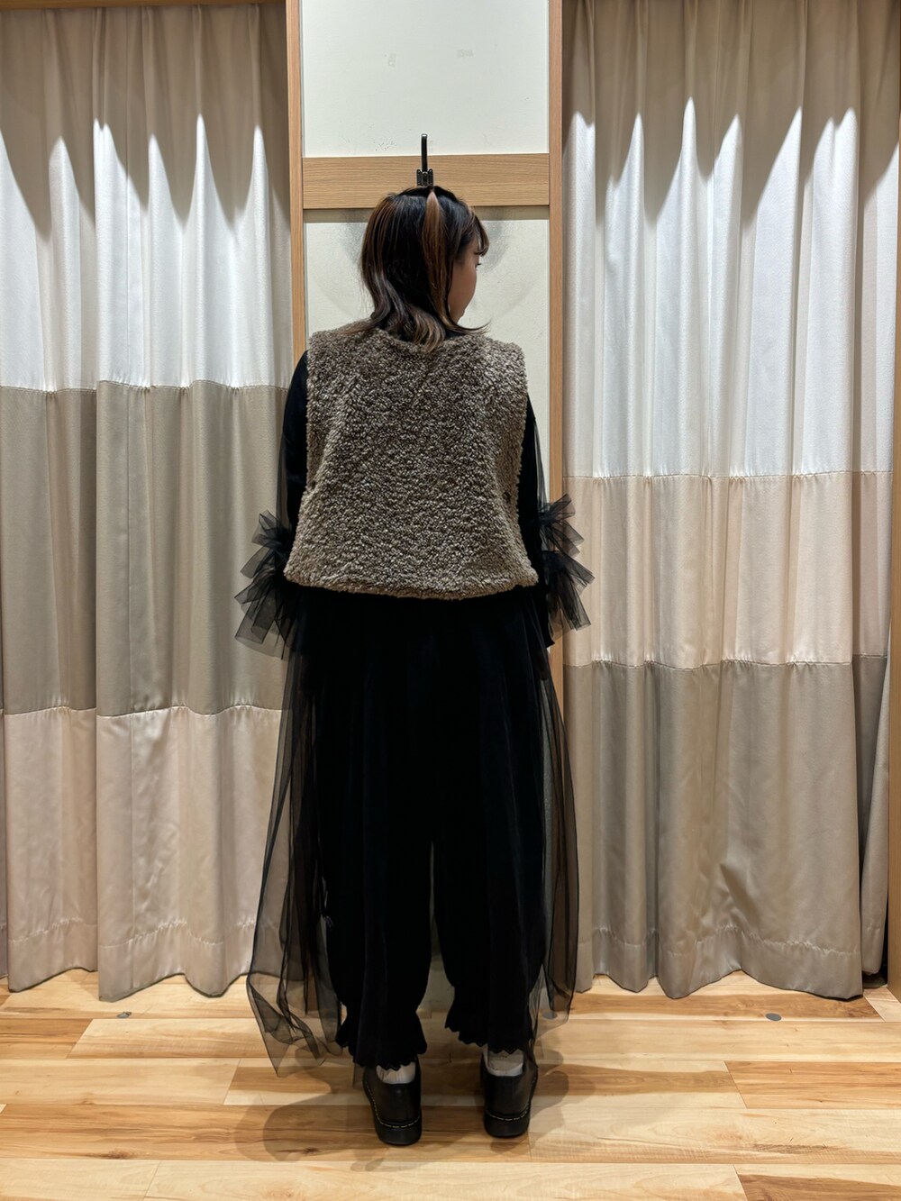 ブラウン系のベスト、ブラック系のワンピース、ブラック系のその他パンツを着用したレディースの秋コーディネートの3枚目の写真